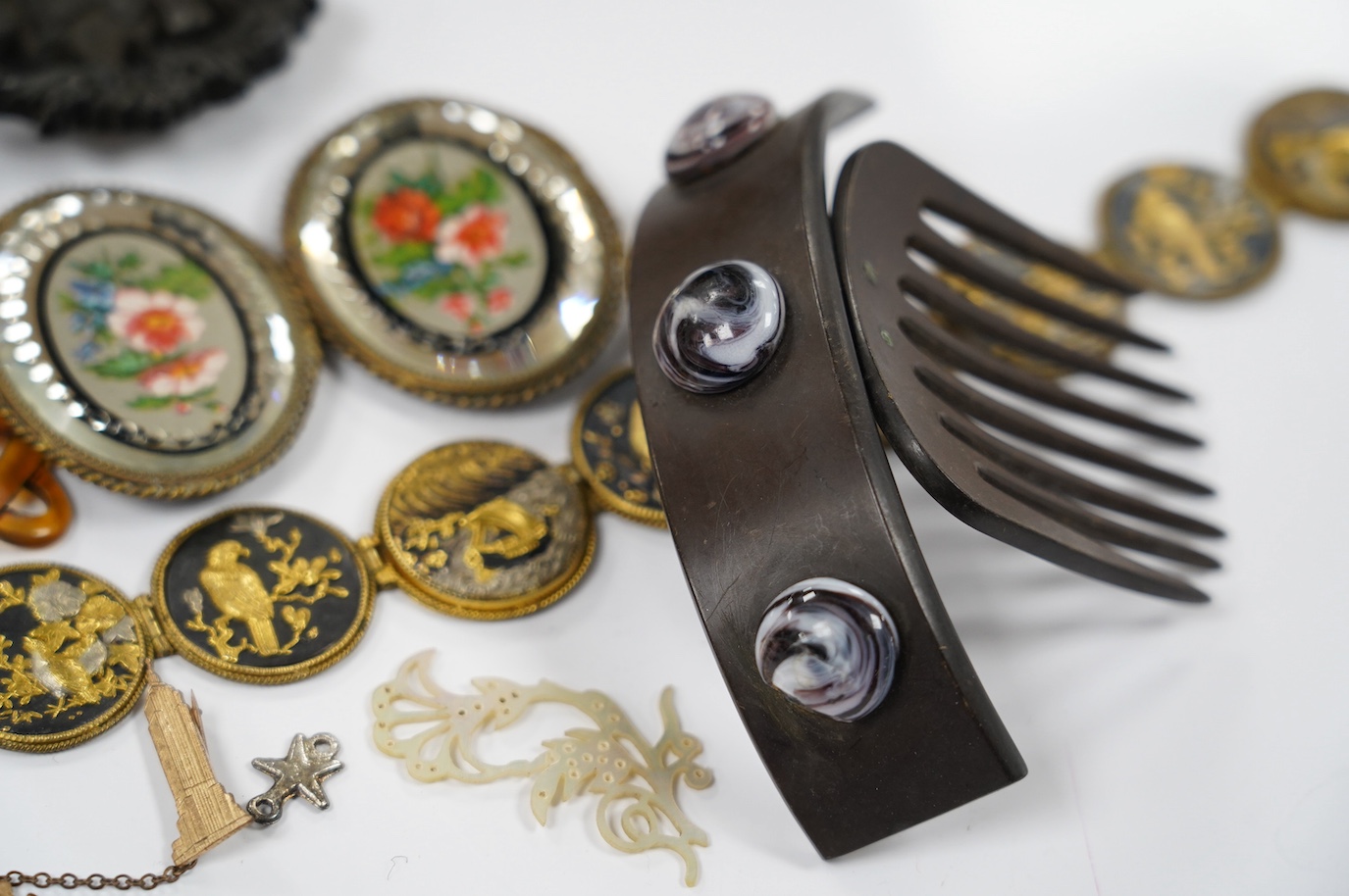 A French Bois Durci brooch, a French carved and stained horn pendant, a hair comb, ornate glass belt buckle and Japanese mixed metal choker necklace 36cm long. Condition - good